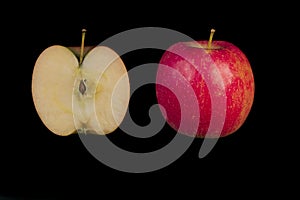 Whole and sliced apple on black background